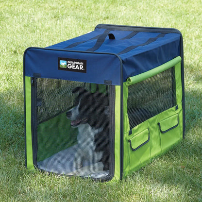 Green and blue pet crate with a dog inside on grass